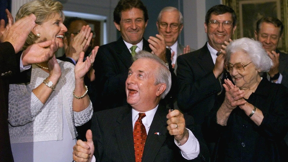 Jim Hunt sorri após assinar o pedido em frente ao escritório