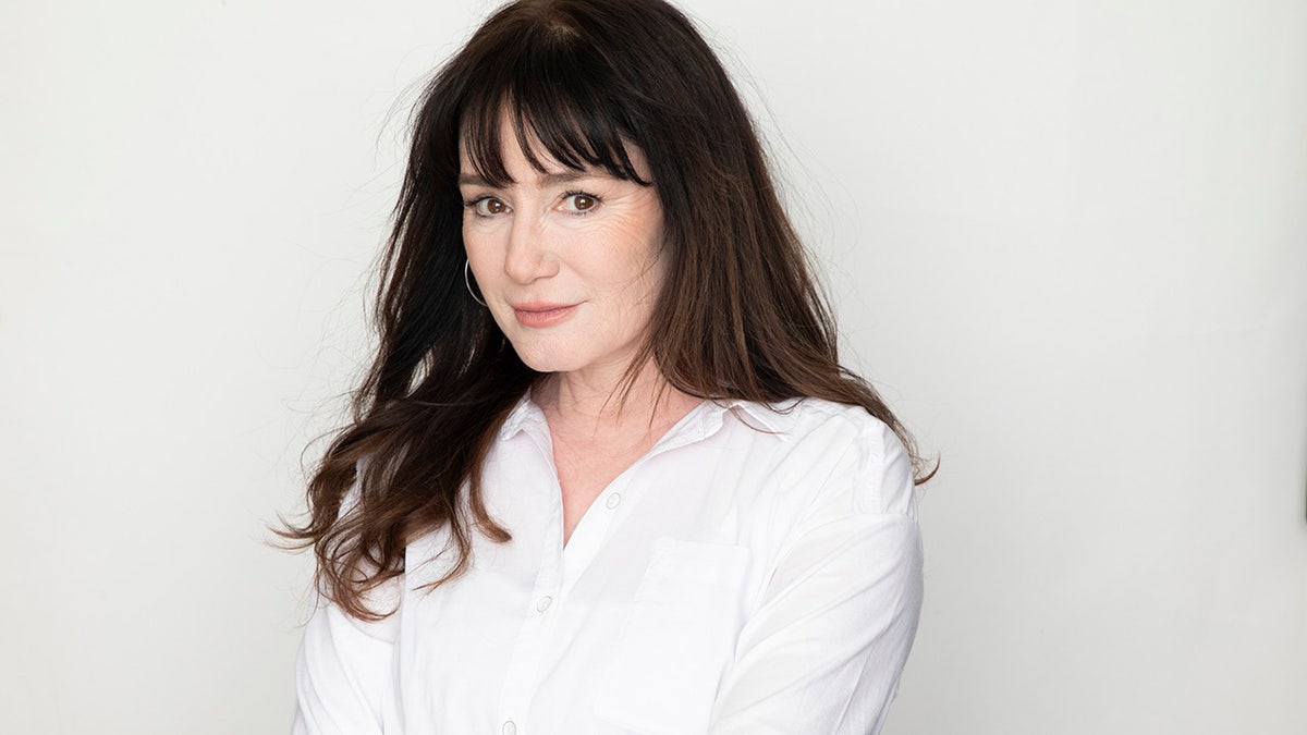 Jill Schoelen wearing a white blouse.