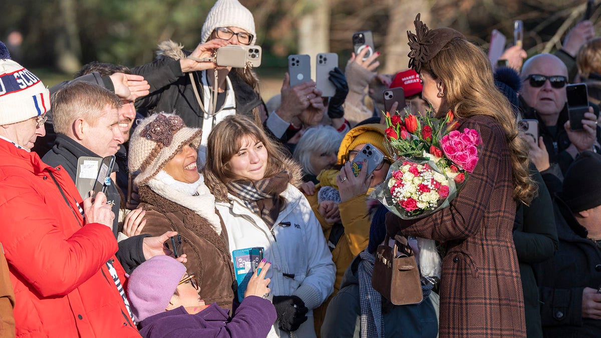 Kate Middleton accepting a bouquet of flowers from the public.