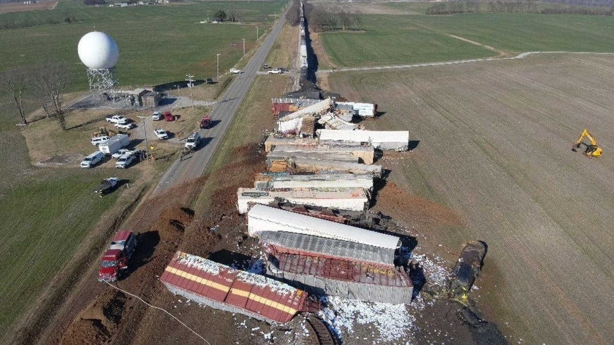 Aerial view of derailed freight train cars resting against one another along tracks in rural Kentucky.