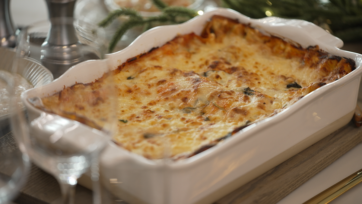 Lasagna is shown in a dish on a table.