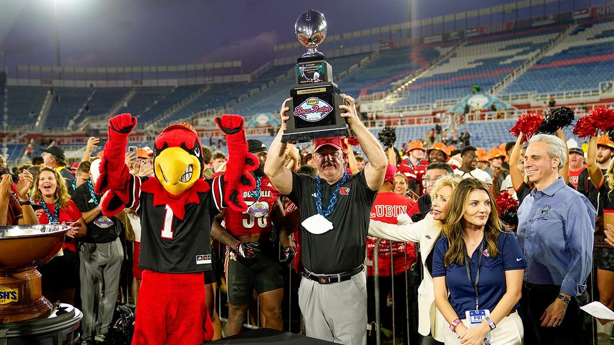 Louisville's Jeff Brohm holds trophy