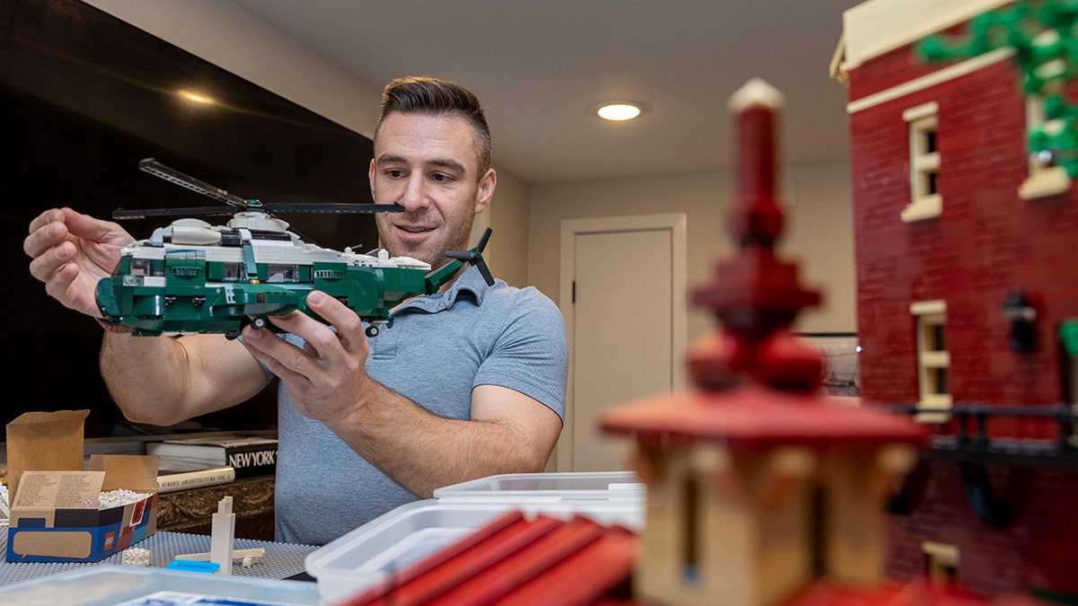Richard Paules holds up a lego replica of Marine One that he is custom building for a friend.