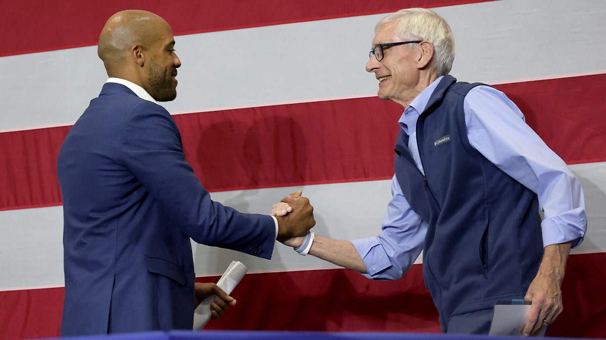 Tony Evers and Mandela Barnes greet each other at a campaign rally.