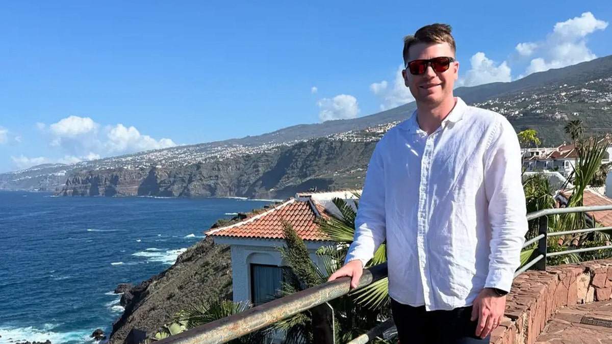 Man in white button up shirt in coast city. 