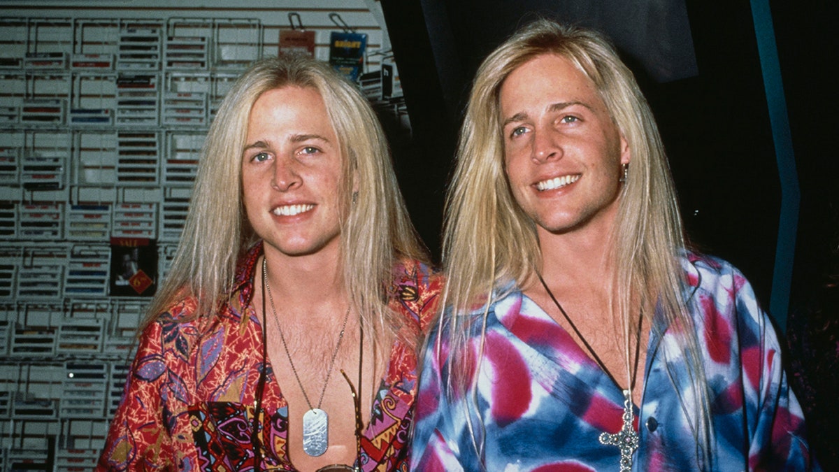 Primer plano de la banda Nelson, con su cabello rubio suelto y camisas de colores, sonriendo.