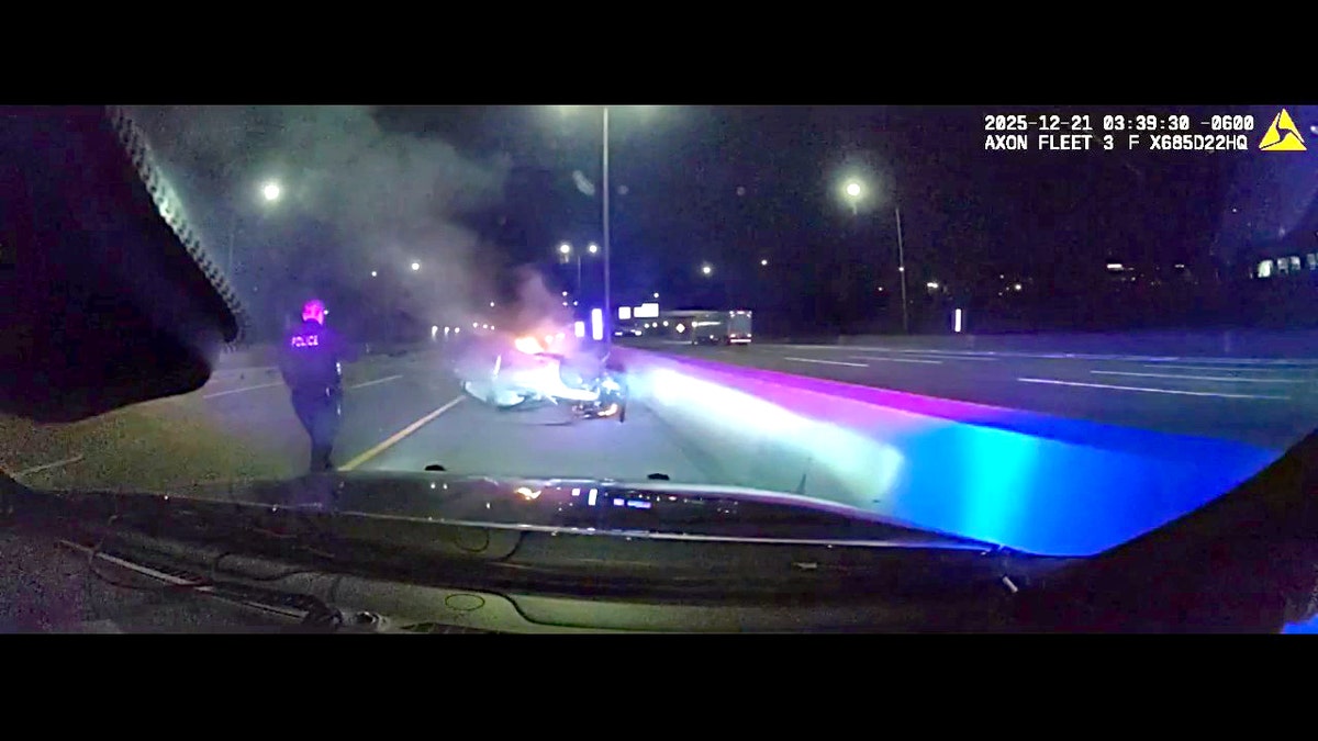 Officer walks up to overturned, burning car
