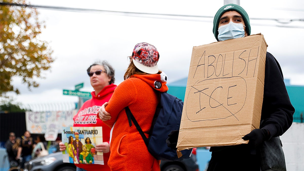 Demonstrators hold signs while picketing outside Hoover Elementary School in Oakland in response to reports of a failed ICE arrest.
