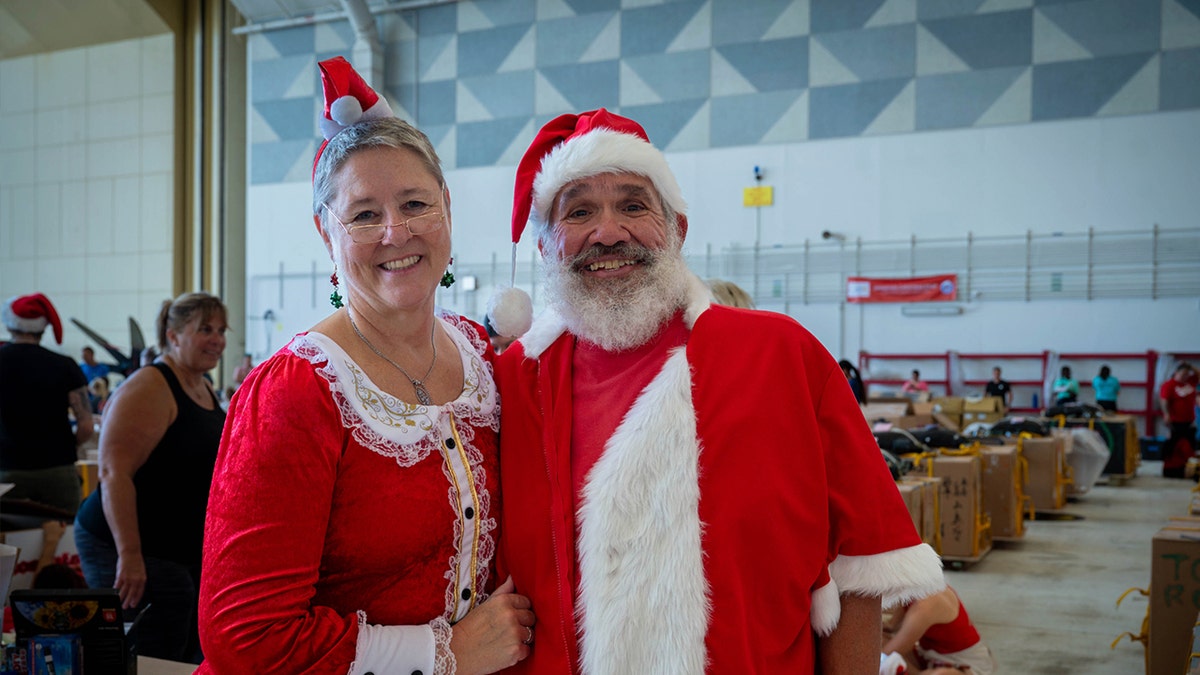Beth and Jeff Roman, Operation Christmas Drop 2025 volunteers, pose for a photo during the bundle build and decoration for OCD25 at Andersen Air Force Base, Guam, Dec. 5, 2025.