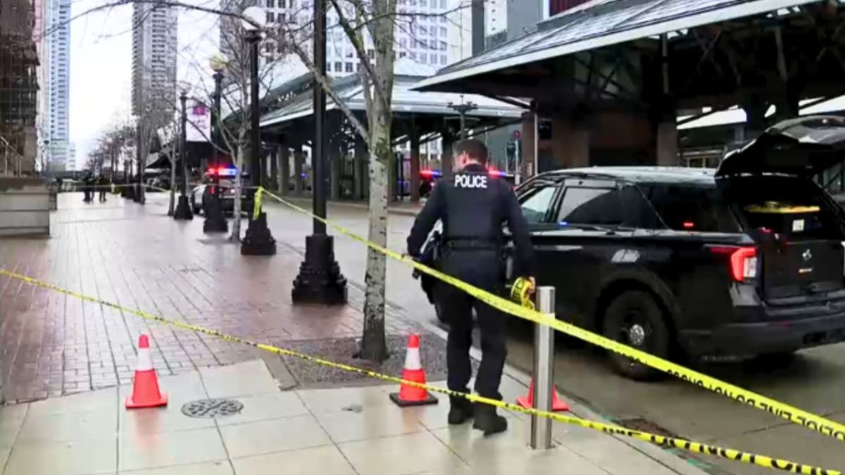 Bellevue police officer putting up crime scene tape after stabbing