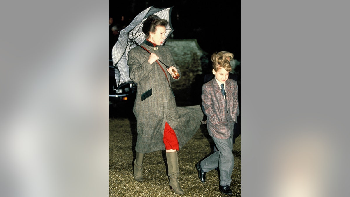 Princess Anne holding an umbrella next to a young Prince William.