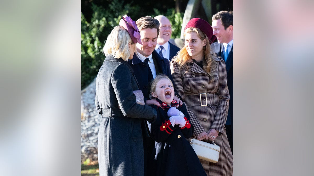 One of the Tindal children is seem making a funny face with the royal family.