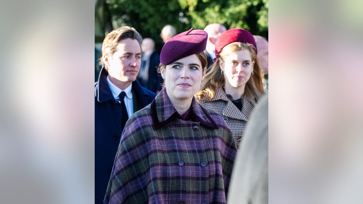Princess Beatrice looking concerned in a purple patterned coat and a matching hat.