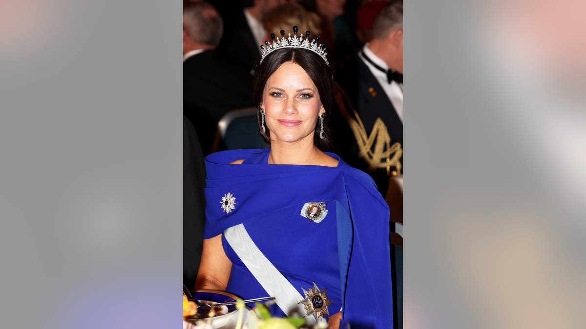 Princess Sofia of Sweden wearing a royal blue gown and smiling with a tiara.