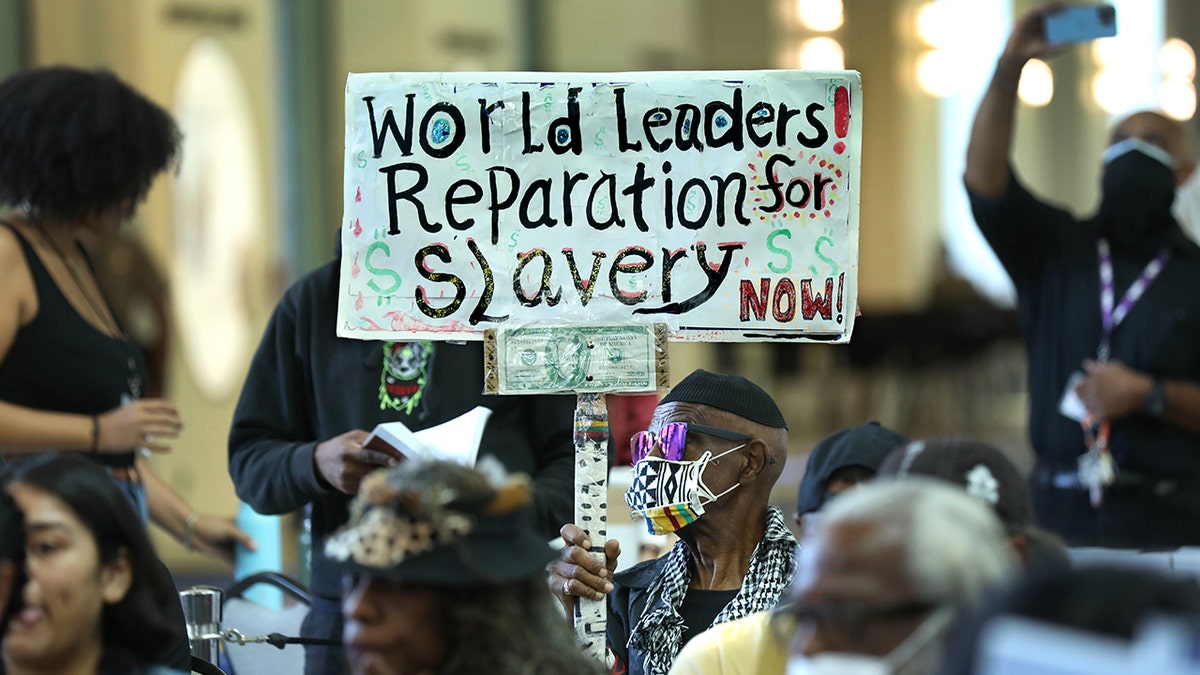 A pro-reparations sign held up at meeting