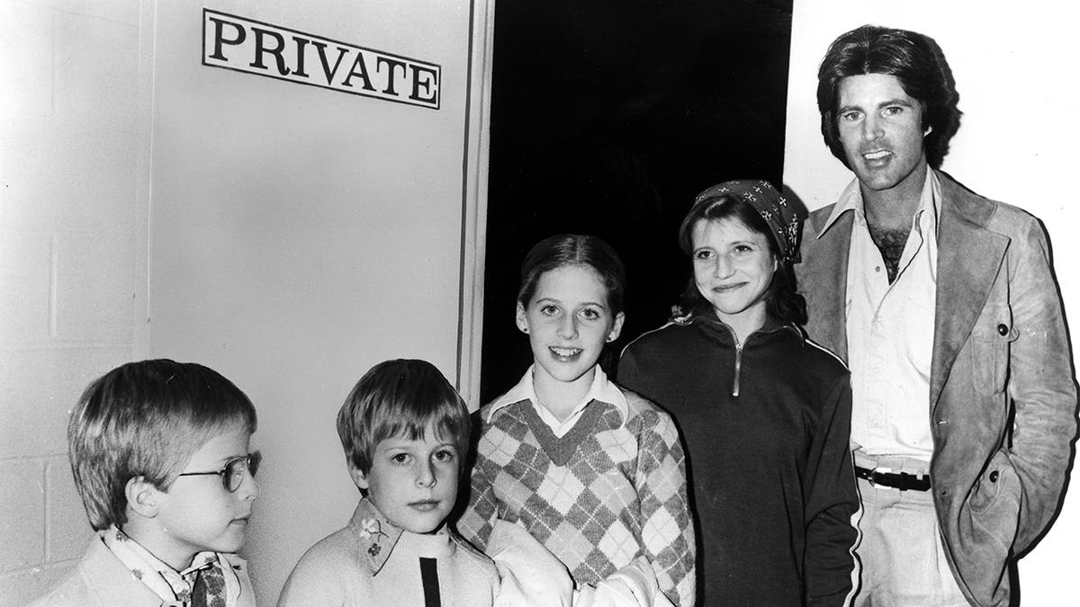 Ricky Nelson smiling next to his young family.