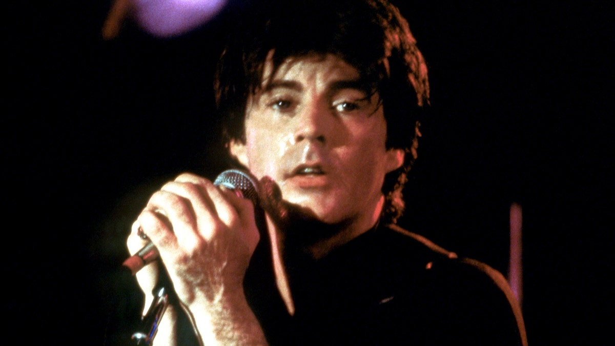 Ricky Nelson on stage looking away from his camera.