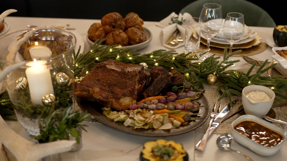 David Burke's Roasted Spice-Crusted Prime Rib is shown on a platter at a dinner table.