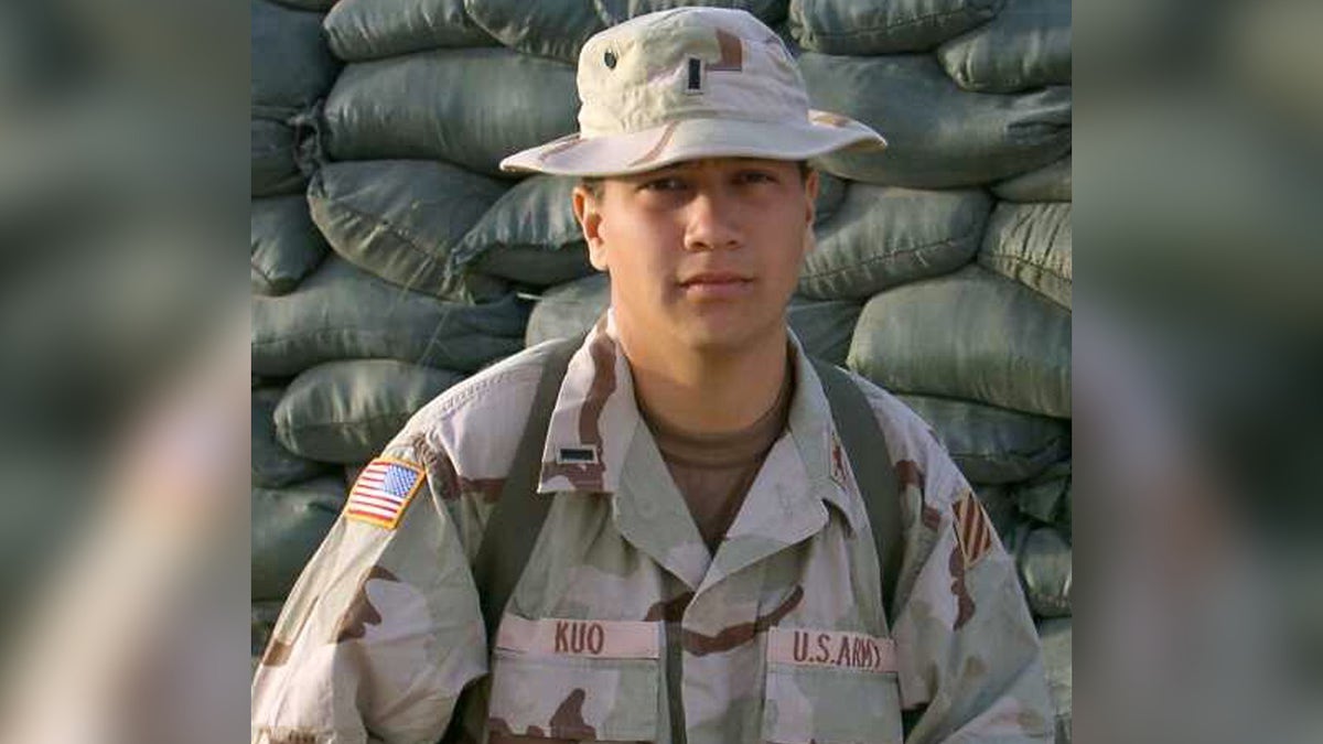 Photo from early 2000s of Ryan Kuo serving in US Army, seen in uniform, bucket hat.
