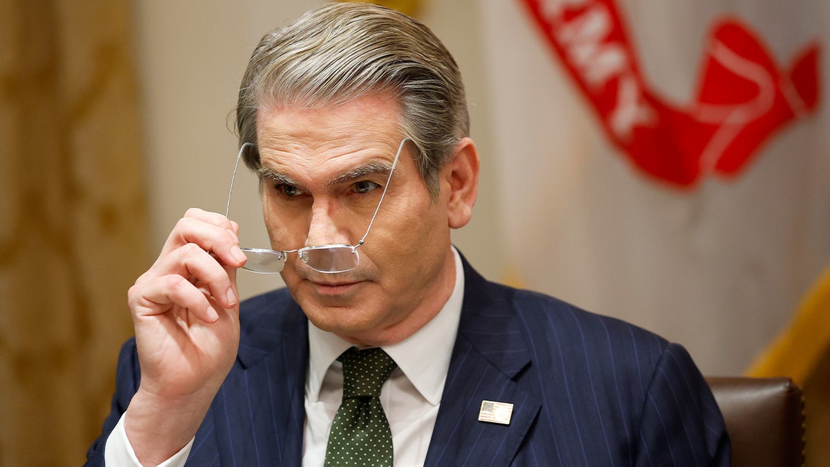 Scott Bessent fixes his glasses