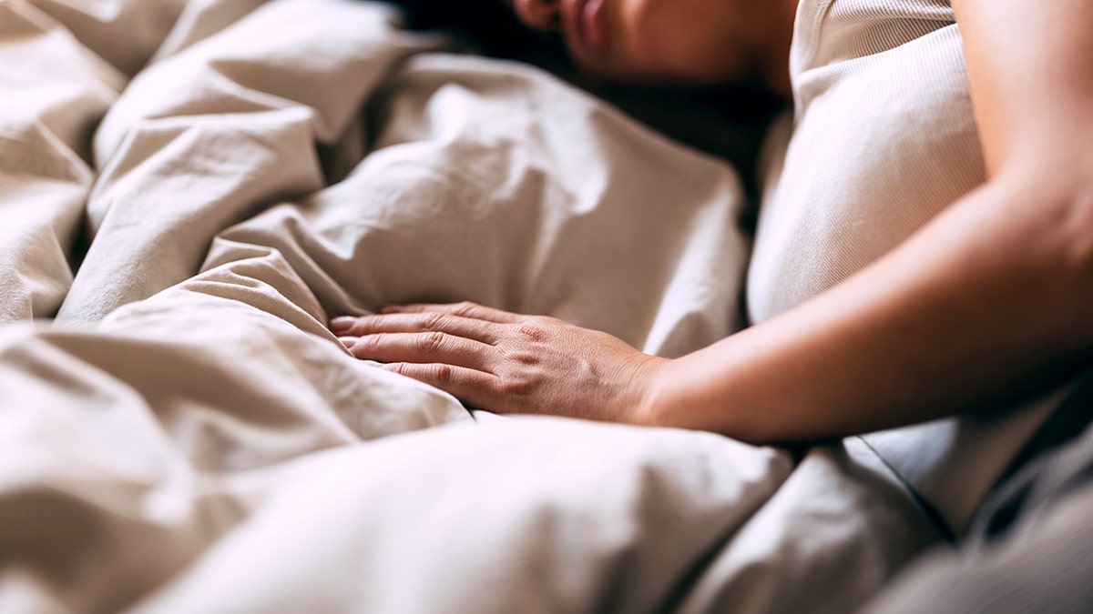 A serene image of a woman sleeping peacefully in bed, conveying comfort and rest. The soft lighting and cozy setting create a calm and relaxing atmosphere.