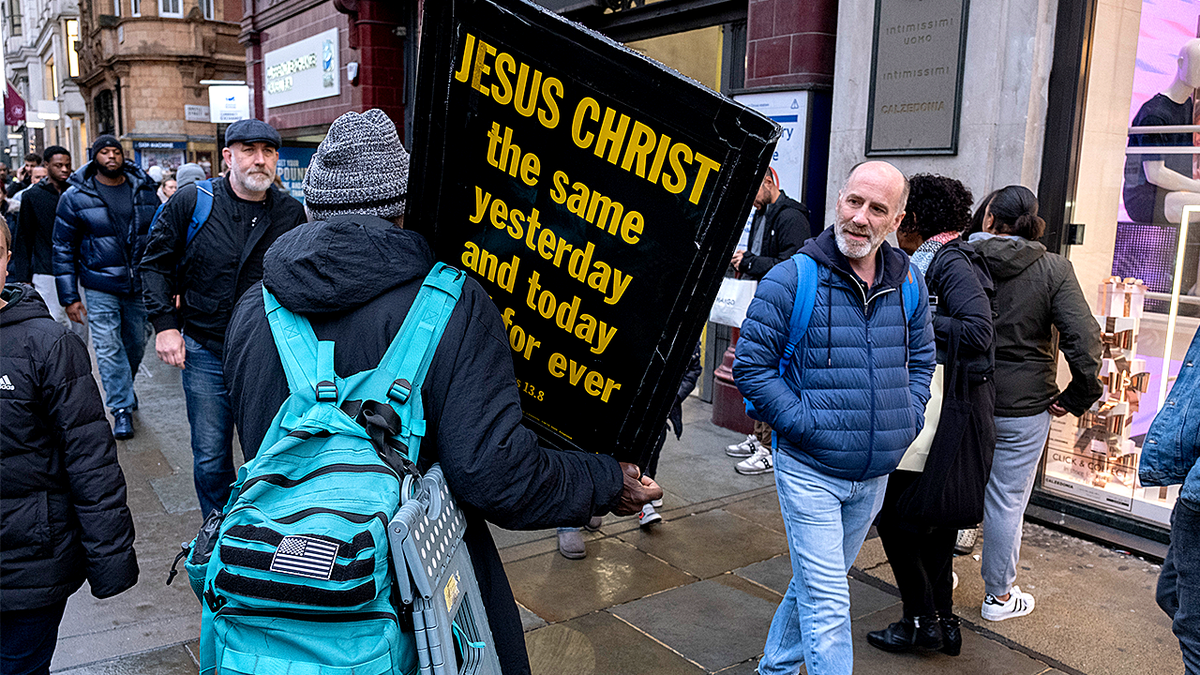 Street preacher in UK holds Jesus sign