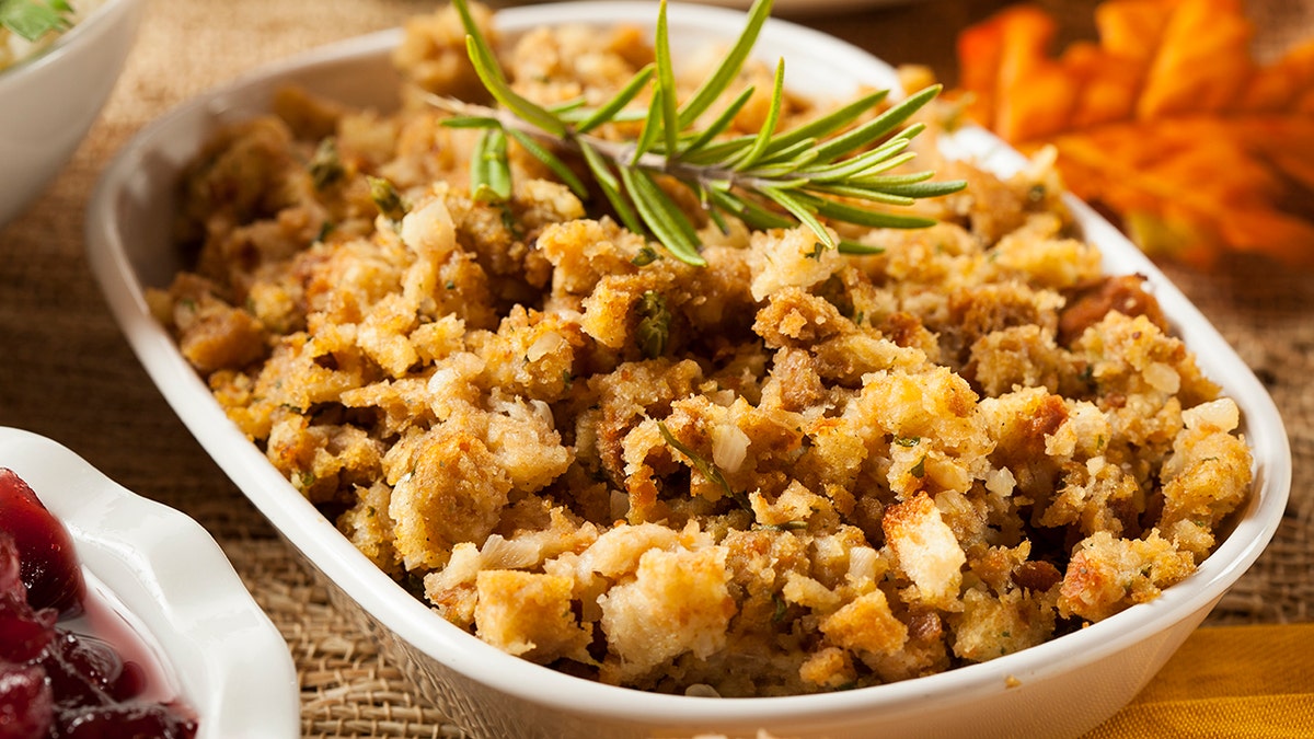 Homemade Thanksgiving Stuffing Made with Bread and Herbs seen on table alongside other side dishes.
