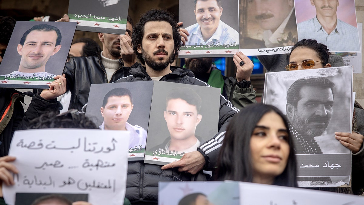 Mourners display photos of missing or killed relatives during a public demonstration in Damascus.