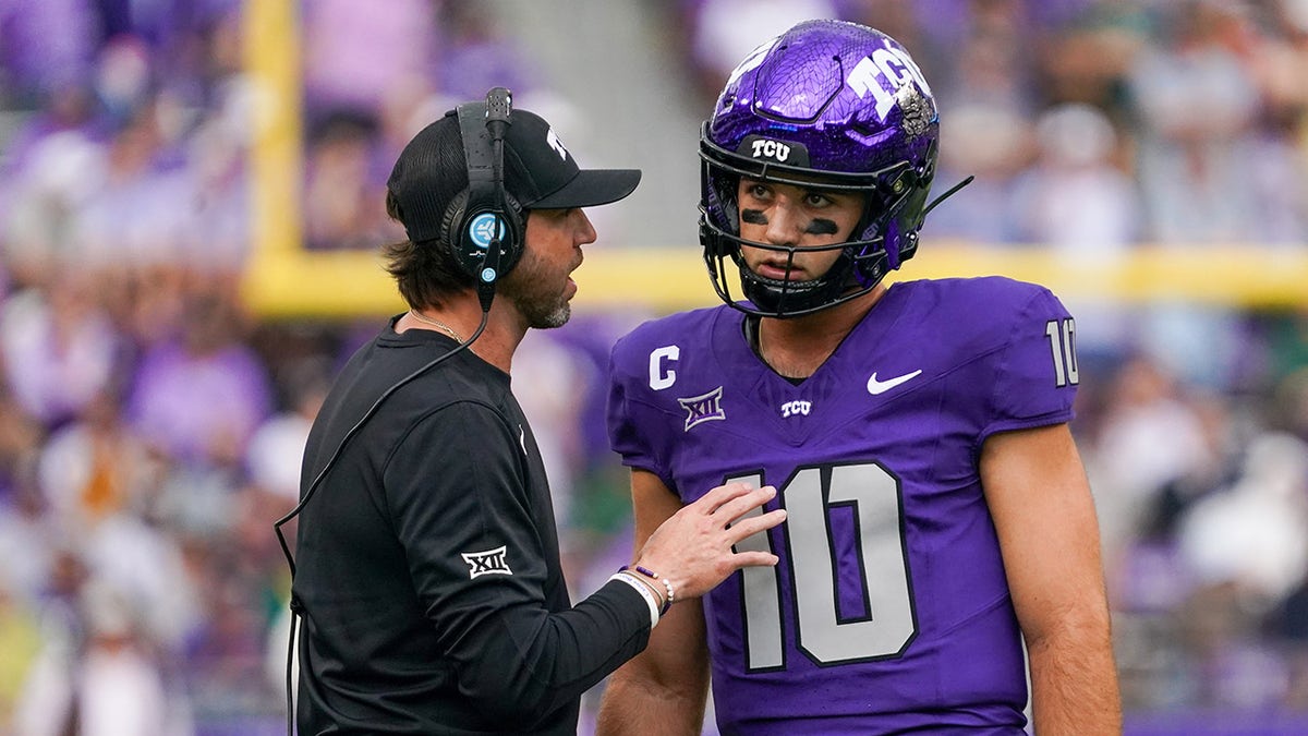 Josh Hoover talks with an assistant coach