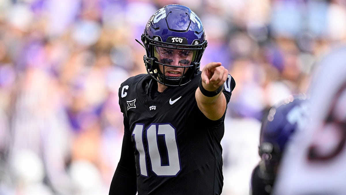 Josh Hoover points at the line of scrimmage