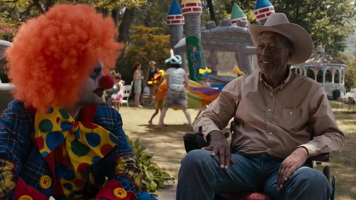 Morgan Freeman and a clown in a screenshot of "The Magic of Belle Island,"