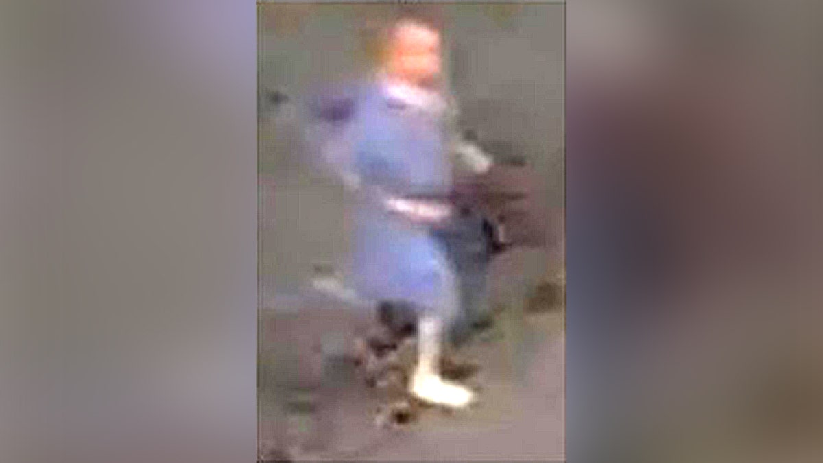 niewyraźne zdjęcie z monitoringu przedstawiające biegnącego mężczyznę w niebieskiej sukni