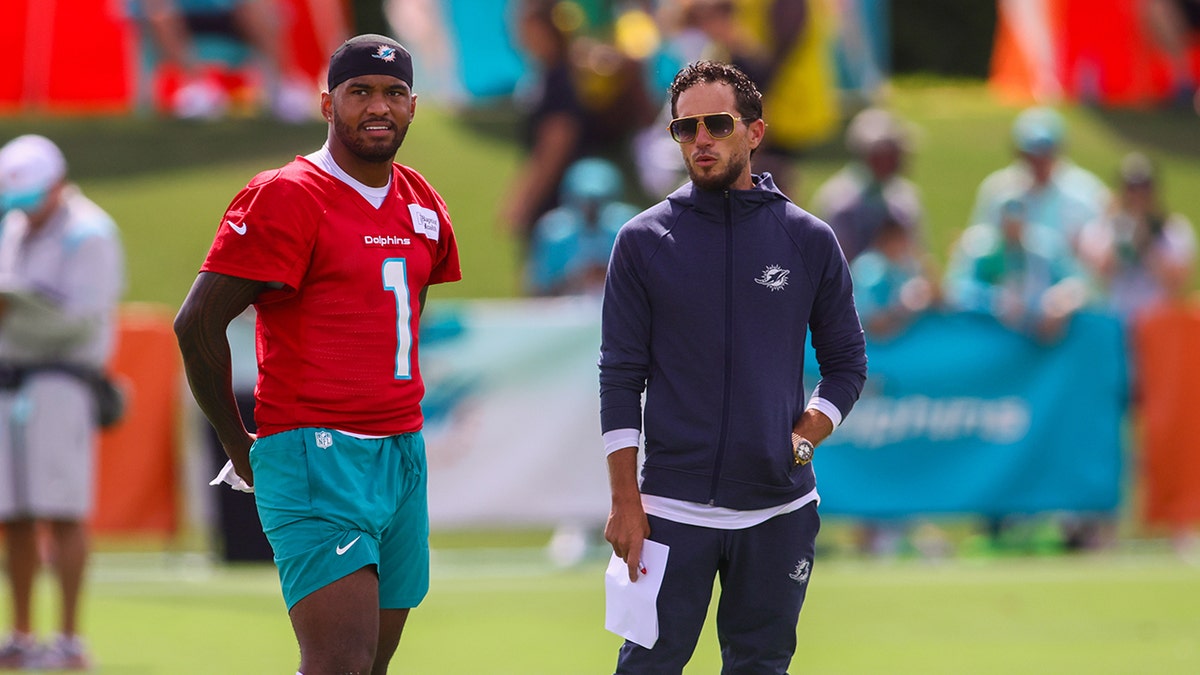 Tua Tagovailoa talks to caput  manager  Mike McDaniel