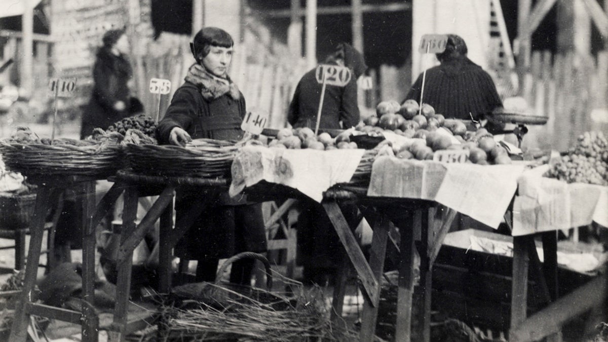 A woman selecting produce in a civilian market during WWI.