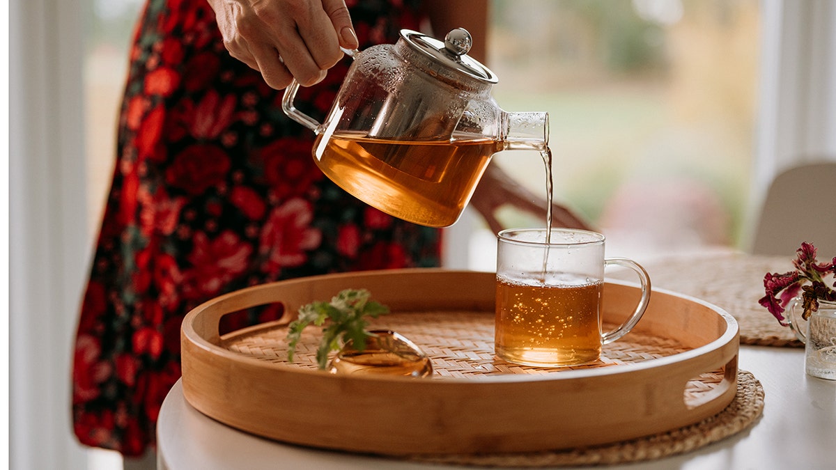 Woman relaxing on a couch while drinking a hot beverage from a mug at home.