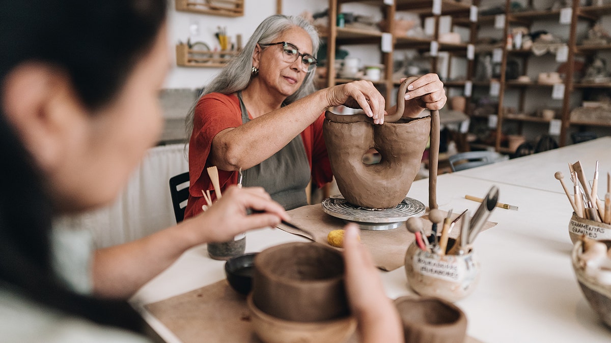 Mulheres trabalhando em projeto de cerâmica em uma aula.