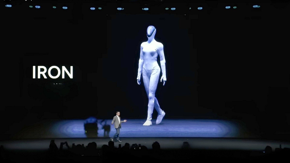 Xpeng CEO He Xiaopeng on stage in front of a robot slide