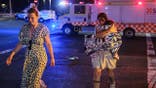 Two women and a child leave the scene of a shooting