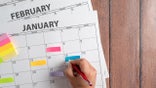 person making notes on calendar
