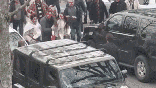 A group of men getting into a fight with a crowd behind them
