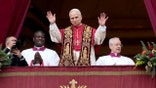 The pope raises his hand in farewell from a balcony above a large crowd gathered in St. Peteru2019s Square.