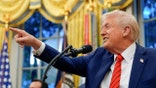 Trump smiles and points