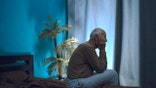 Silhouette of lonely exhausted man at edge of bed