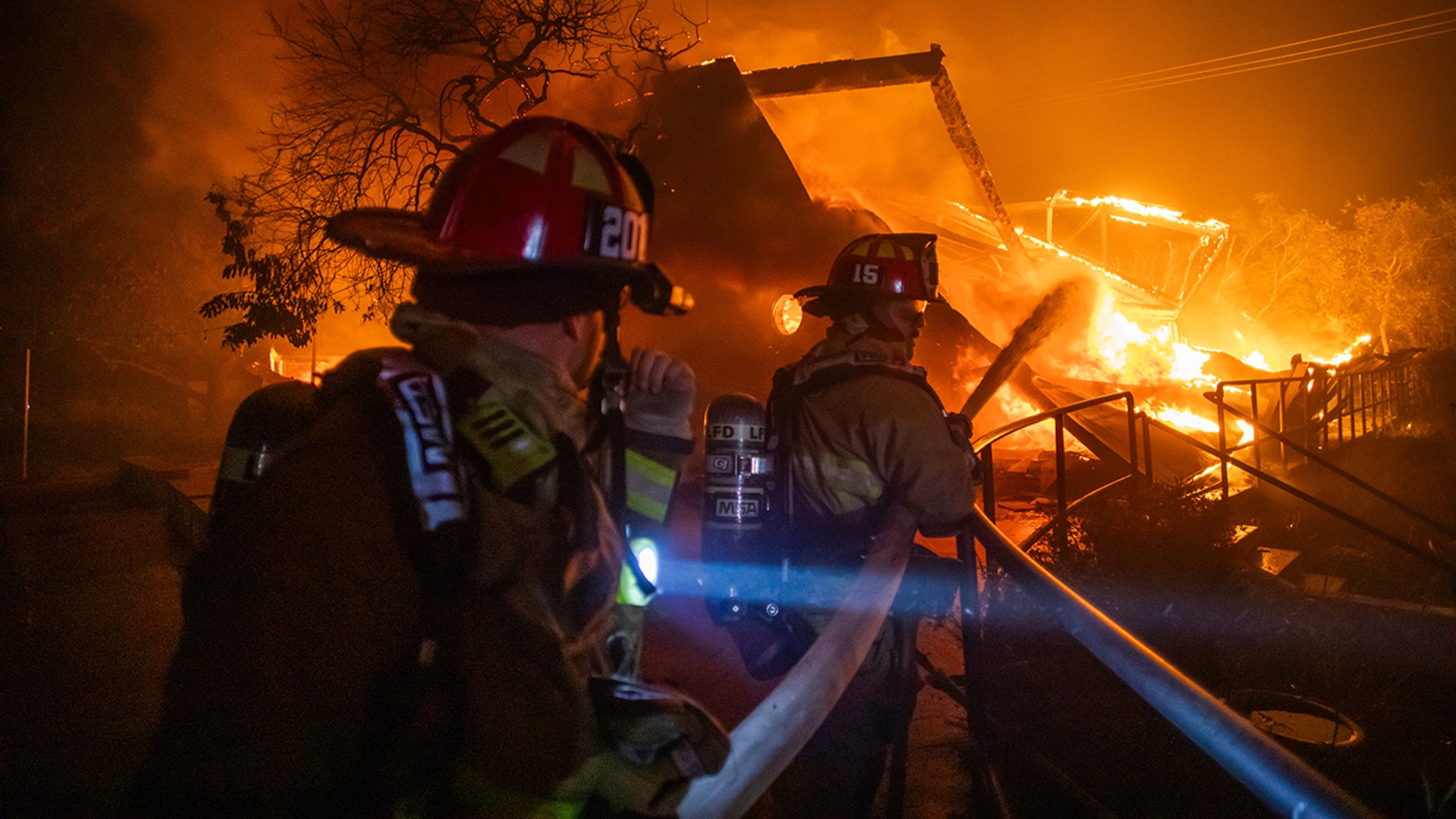 Firefighters fight the flames from the Palisades Fire