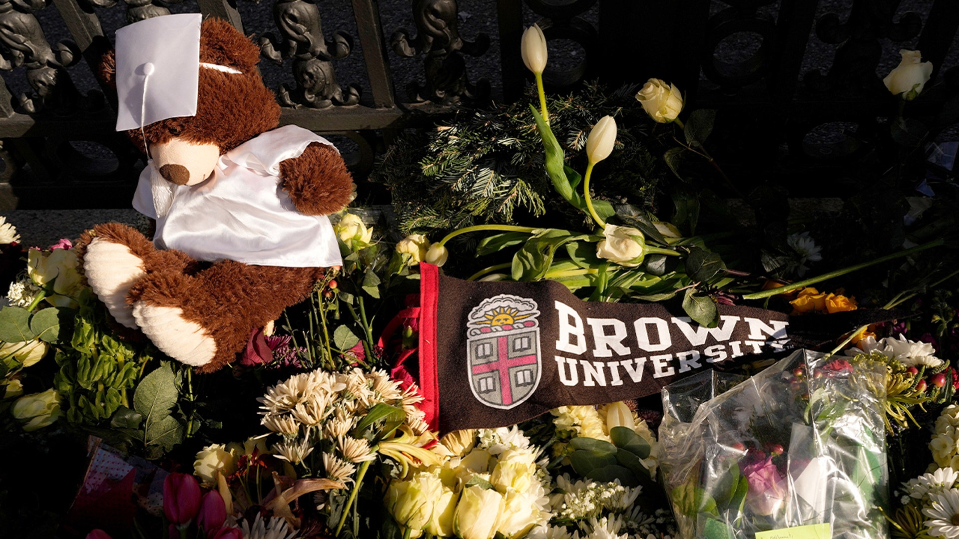 Flowers are arranged at an outdoor memorial on a university campus.