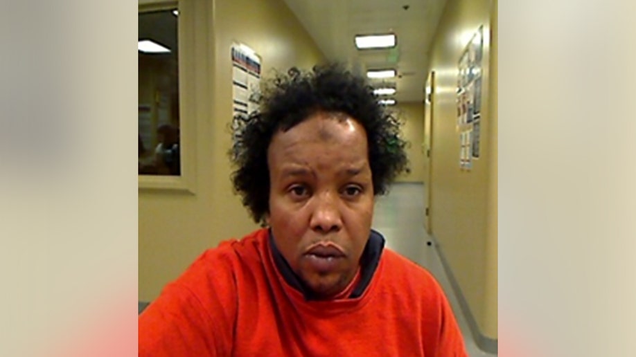 Man with orange longe-sleeve poses for head on picture.