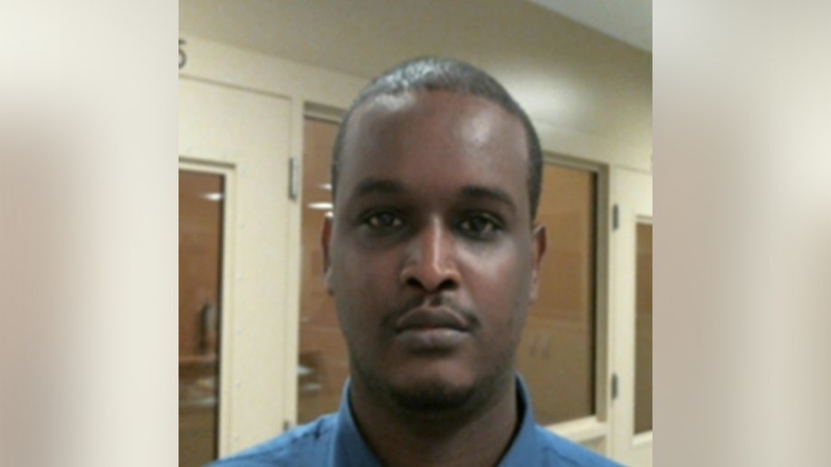 Man posing for a head on picture in front of a door and window.