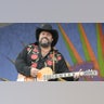 Raul Malo wears cowboy hat and strums guitar