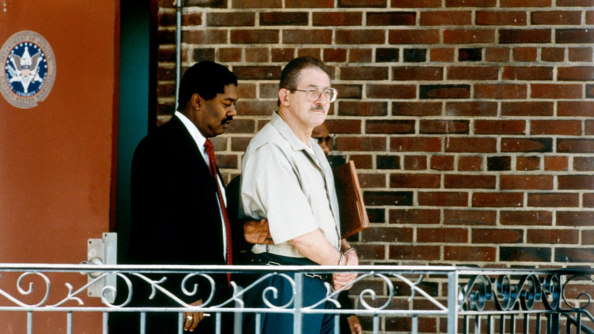 Convicted spy Aldrich Ames walking beside another man as he exits a federal courthouse following sentencing.