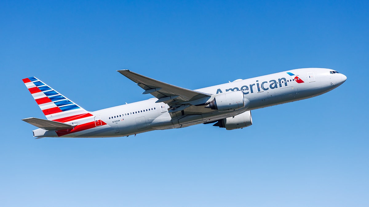 American Airlines passenger jet taking off against a clear blue sky.